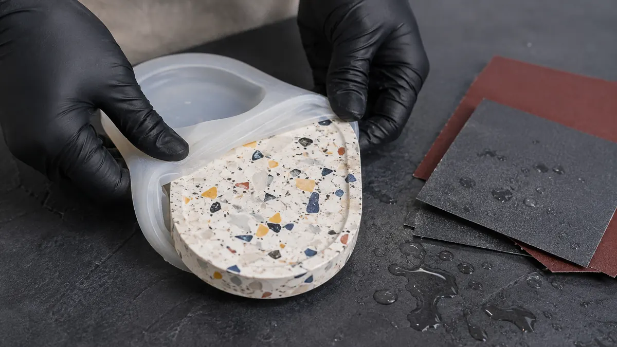 Desmolde de una bandeja ovalada de terrazzo desde un molde flexible de silicona